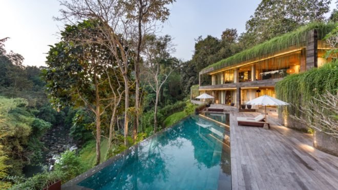 pool and patio outside of the house with forest views