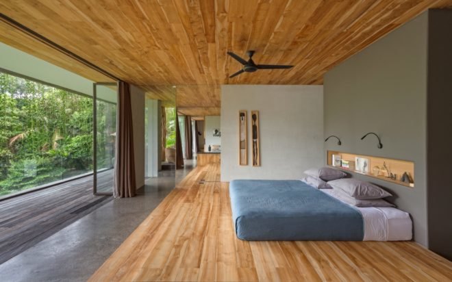 bedroom with large bed on wood floor and doors open to outdoor balcony