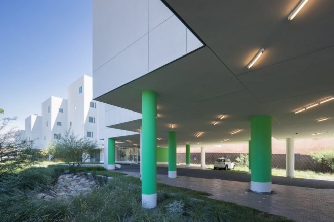white apartment building with green pillars