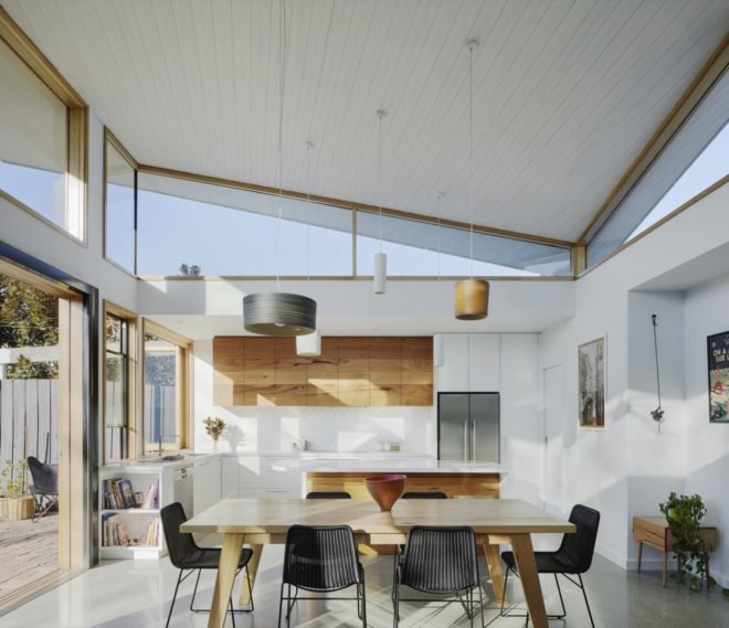 open kitchen and dining space with white and wood cabinets and a light wood dining table