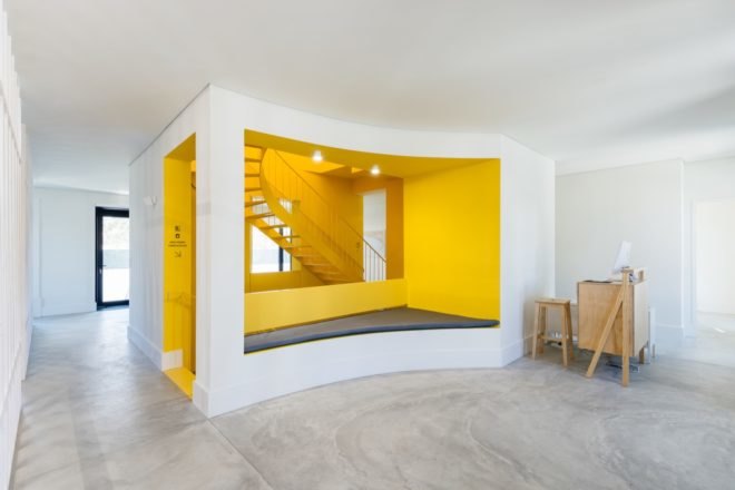 White room leading to the bright yellow staircase area