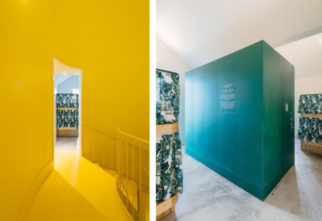 On the left, bright yellow staircase. On the right, green cube in the middle of bedroom. This green cube is a bathroom unit.