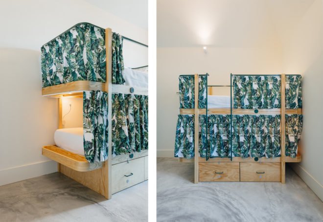 bunk-beds made from light timber with palm leaf printed privacy curtains