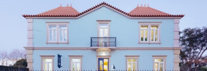 Pale blue hostel with open front door to bright yellow room
