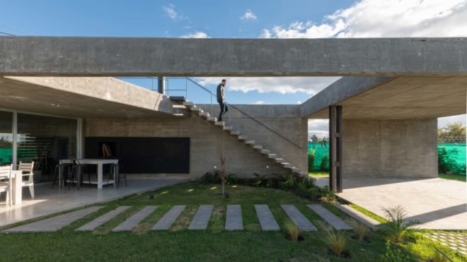 staircase leading down exterior of home to lawn with stone steps