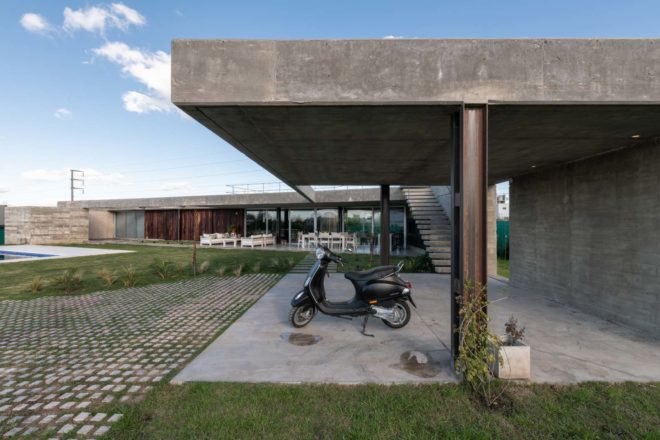 moped sitting on concrete patio under concrete roof