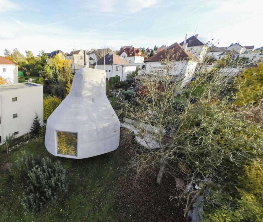 Aerial view of mushroom-shaped home surrounded by traditional homes