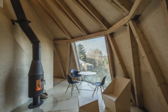 black wood-burning stove with geometrical plywood furniture and a geometric black and white dining set