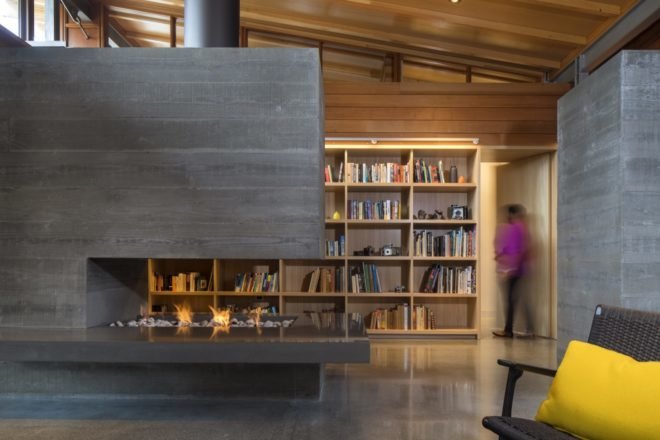 concrete fireplace with bookshelf in background
