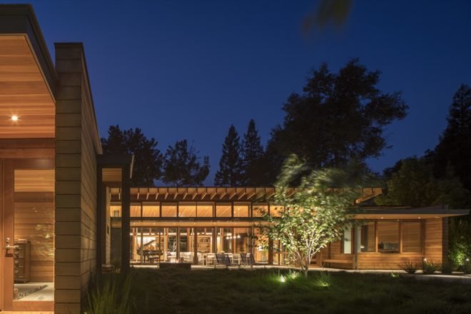 modern home with large windows lit up at night