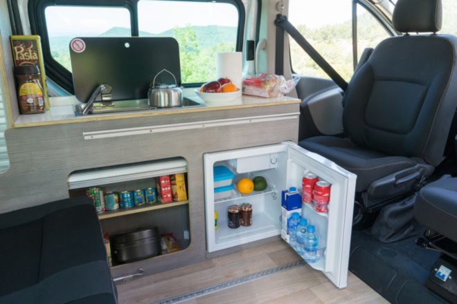 small kitchen space with mini-fridge inside camper van