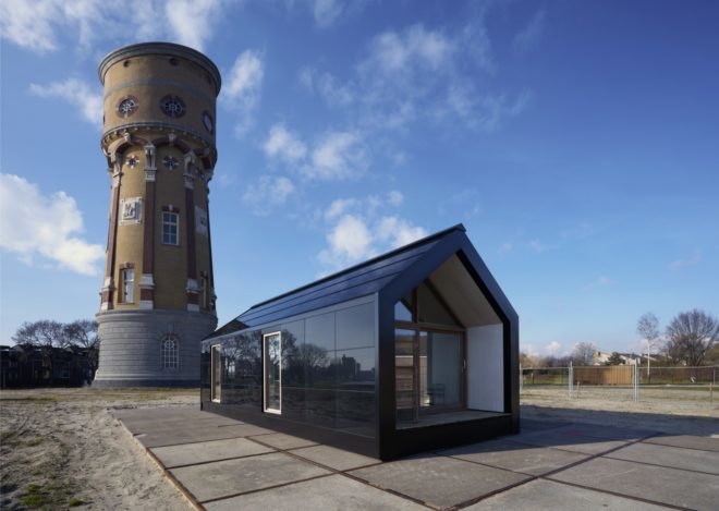 black tiny house with tower in background