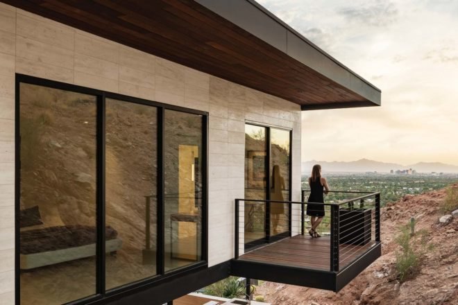 woman standing on balcony overlooking desert