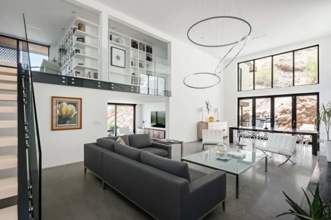 modern living room with couch, large windows and staircase