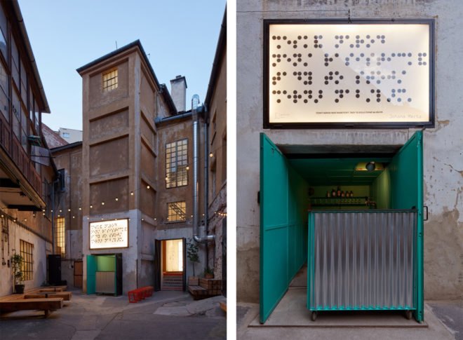 Tall building with outdoor seating and bright teal entrance