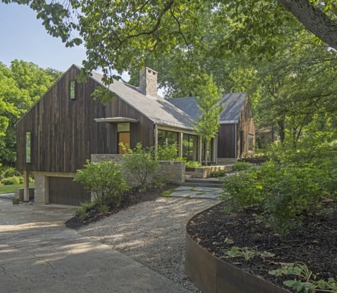 gravel and stone path leading to entrance of wood and stone farmhouse