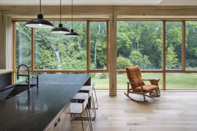 living area large windows, dark kitchen island and a rocking chair