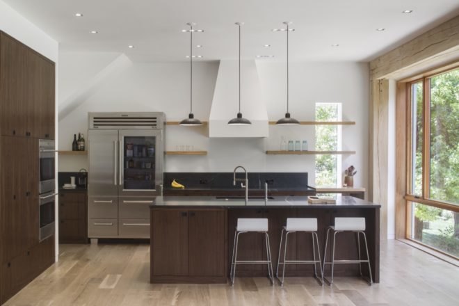 kitchen with dark wood cabinets, dark countertops, large stainless steel fridge