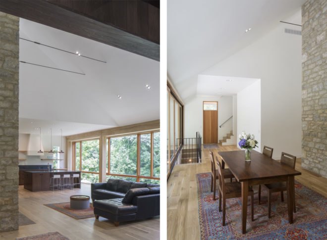On the left, dark couch with kitchen behind it. On the right, wood dining table and chairs with vase of flowers on the table