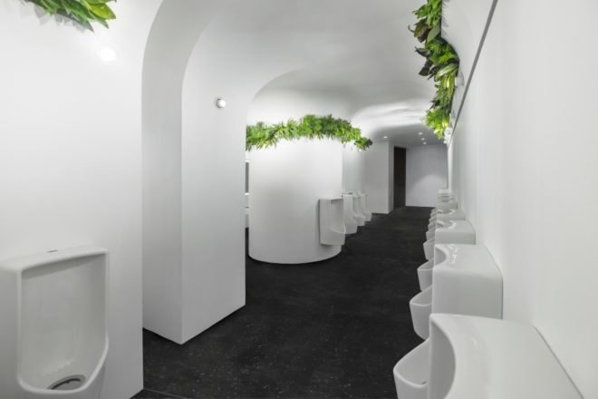 waterless urinals and green plants near the ceilings