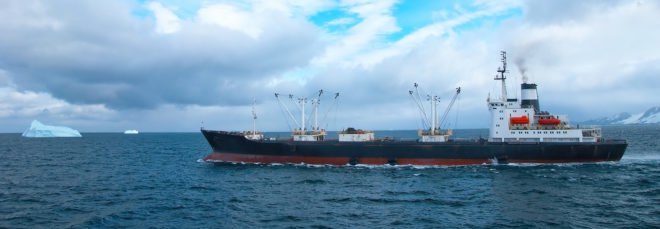 Fishing trawler in ocean near icebergs