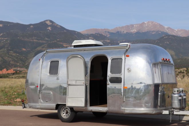 vintage Airstream with open door and mountainous background