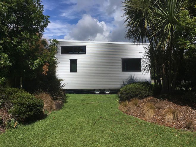 exterior view of the back of tiny home with white siding