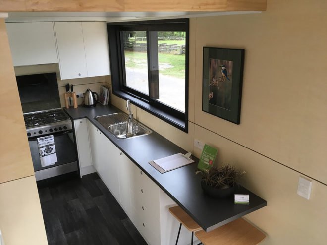 overhead view of kitchen with white cabinetry, dark countertops and a full-size oven