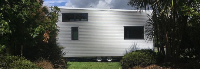 exterior view of the back of tiny home with white siding