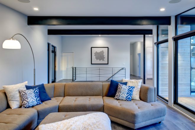 Living area with large gray section couch and plenty of full-height windows