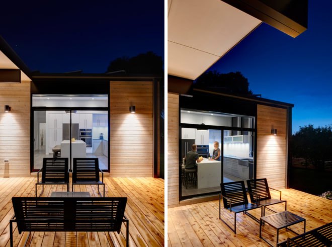 Outdoor deck with black metal seats and coffee table at night