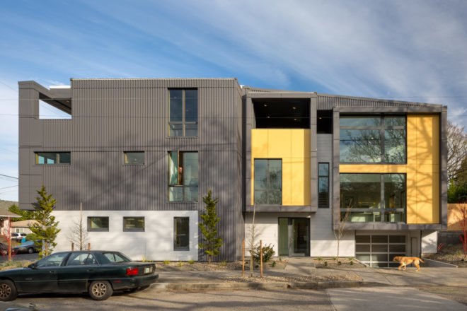 Side view of a boxy modern home with black and yellow paneling