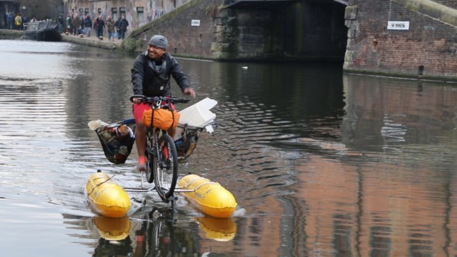 Man on floating bike collecting trash