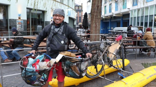 Man standing with two nets full of waste