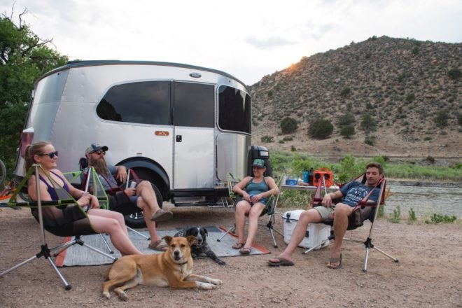 people relaxing in front of an airstream trailer