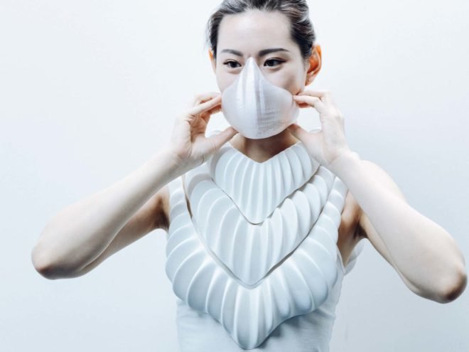 a woman wearing a white face mask and coiled white device