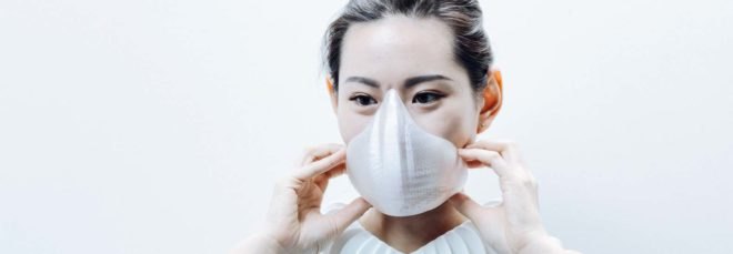 a woman wearing a white face mask and coiled white device