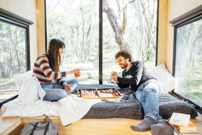 two people playing cards in front of a window