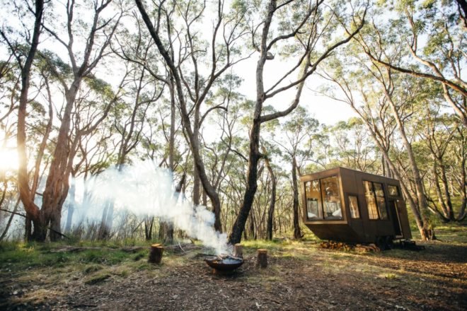 fire pit in front of tiny cabin in the forest
