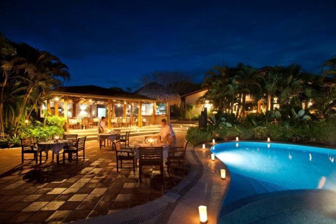 luxury hotel outdoor patio with swimming pool at night