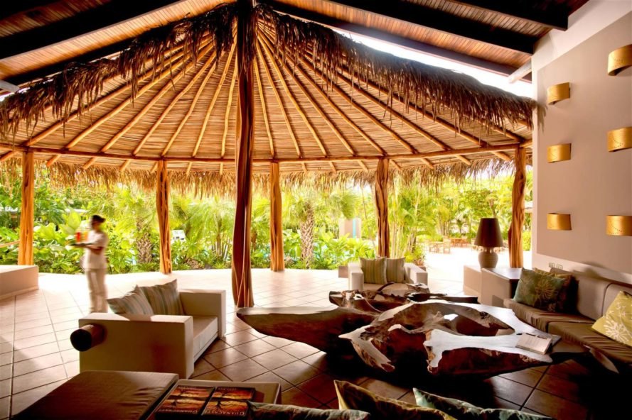 interior of thatched gazebo with lounge chairs