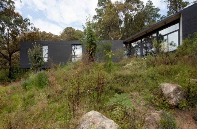 a black home surrounded by trees