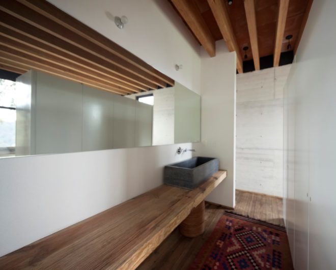 a bathroom with white walls and wooden accents
