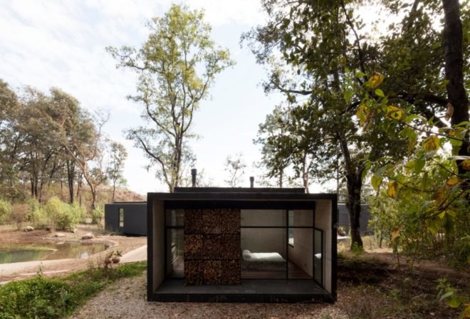 a black home with extra wide floor-to-ceiling windows and stacked wood