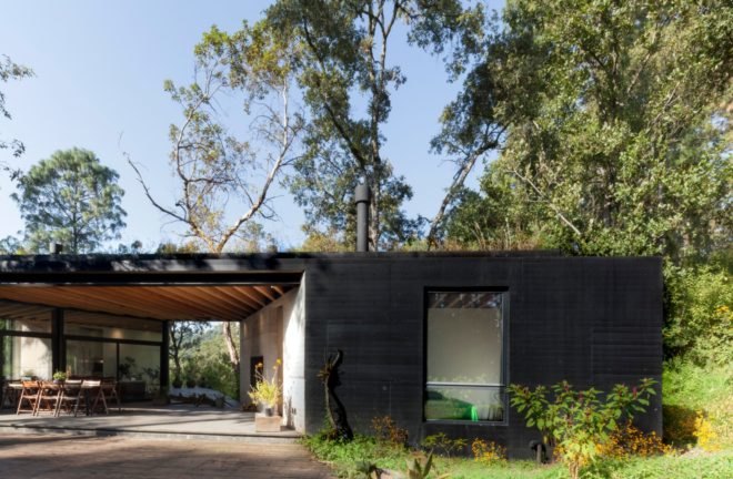 a single story home surrounded by greenery