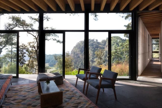 an interior living space with floor to ceiling windows and chairs