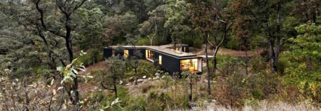 aerial view of dark timber home lit from within