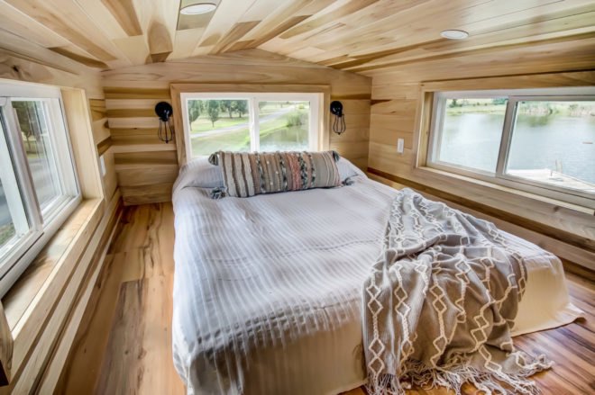 a large bed in a small room with windows