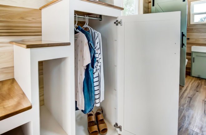 an open closet with hanging clothes