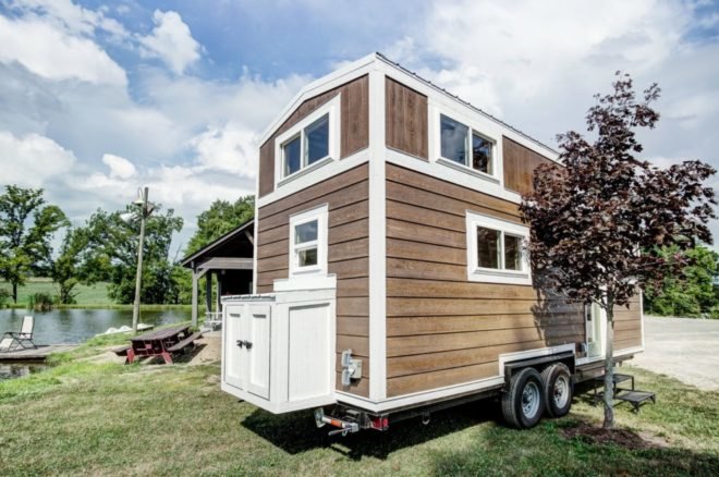 a tiny home on wheels clad in light wood and white trim